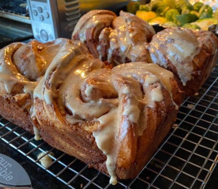 A close-up of 4 cinnamon bakkas with dripping brown butter glaze on a baking rack