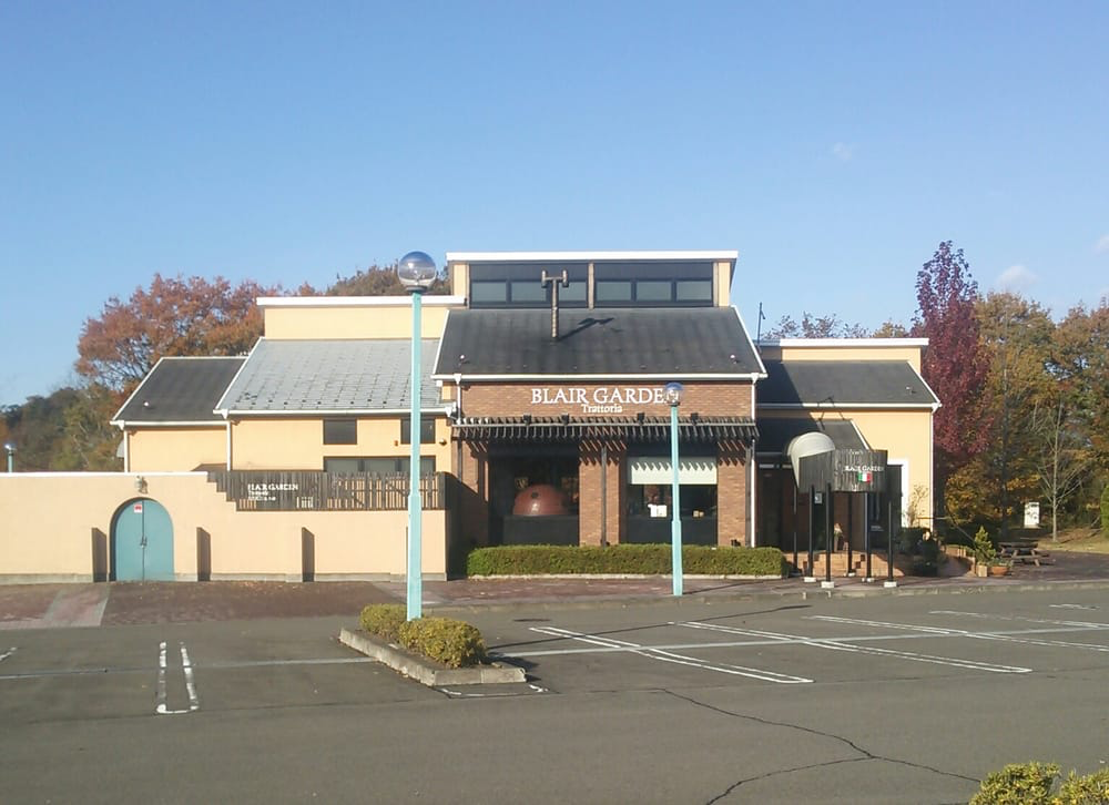 Restaurant building with ‘BLAIR GARDEN’ emblazoned on the front, an empty parking lot making up the foreground.